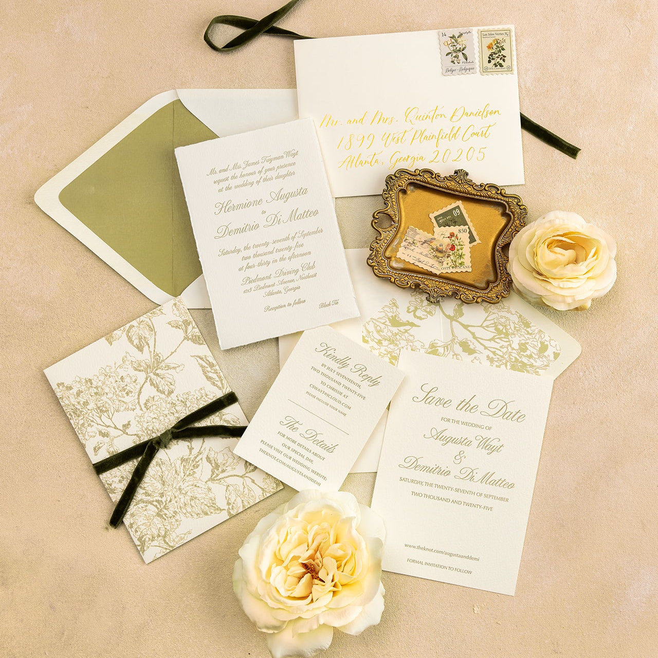 Collection of letterpress wedding invitations and stationery items with velvet ribbons and letterpress invitation wrap on a beige background with flowers. 